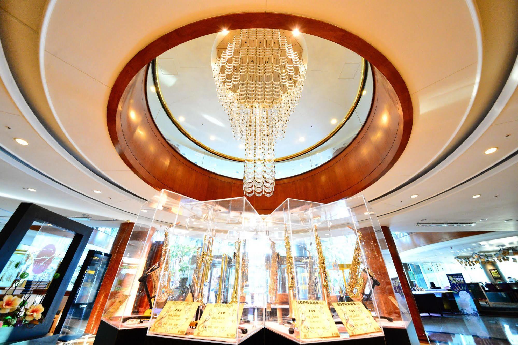 Evergreen Laurel Hotel - Taichung Eksteriør bilde The photo depicts an elegant interior space, featuring a circular chandelier at the center that has a modern design with hanging elements. The ceiling has a smooth, light-colored finish surrounding the chandelier, enhancing the ambiance. Below, there