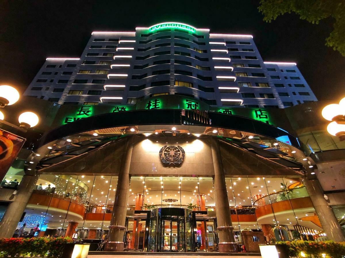 Evergreen Laurel Hotel - Taichung Eksteriør bilde The photo shows a modern building at night, featuring a grand entrance with illuminated signage. The structure has multiple stories with a sleek design, adorned with green lighting that highlights its architectural features. The entrance is spacious 