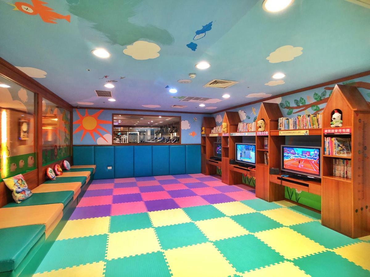Evergreen Laurel Hotel - Taichung Eksteriør bilde The photo shows a brightly colored children's playroom or activity area. The floor is covered with large colorful tiles in shades of blue, green, yellow, and pink, creating a playful pattern. The walls have cheerful decorations, including sun and clo