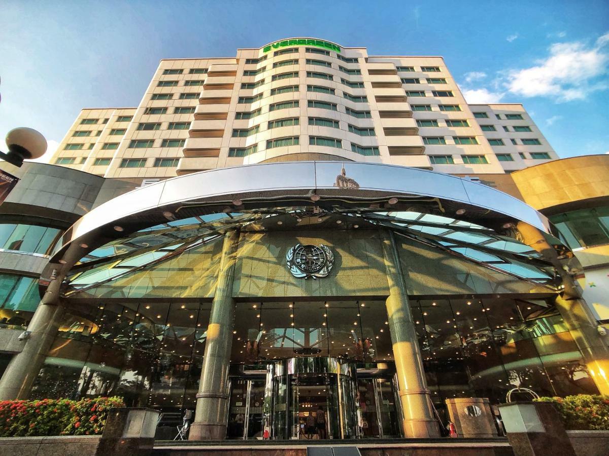 Evergreen Laurel Hotel - Taichung Eksteriør bilde The photo shows the exterior of a modern hotel building. The entrance features a large, glass canopy supported by columns, creating a welcoming area. The facade of the hotel is composed of a mix of glass and concrete, with large windows that suggest 