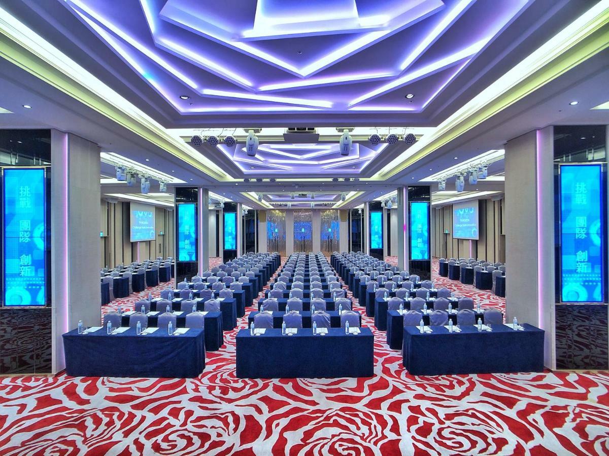 Evergreen Laurel Hotel - Taichung Eksteriør bilde The photo shows a large conference or seminar room set up for an event. The space features rows of tables and chairs arranged neatly, likely for attendees to participate in discussions or presentations. The room is well-lit with modern, colorful ligh